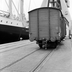 854164 Afbeelding van een gesloten goederenwagen op een kade in de haven van Rotterdam of Amsterdam.